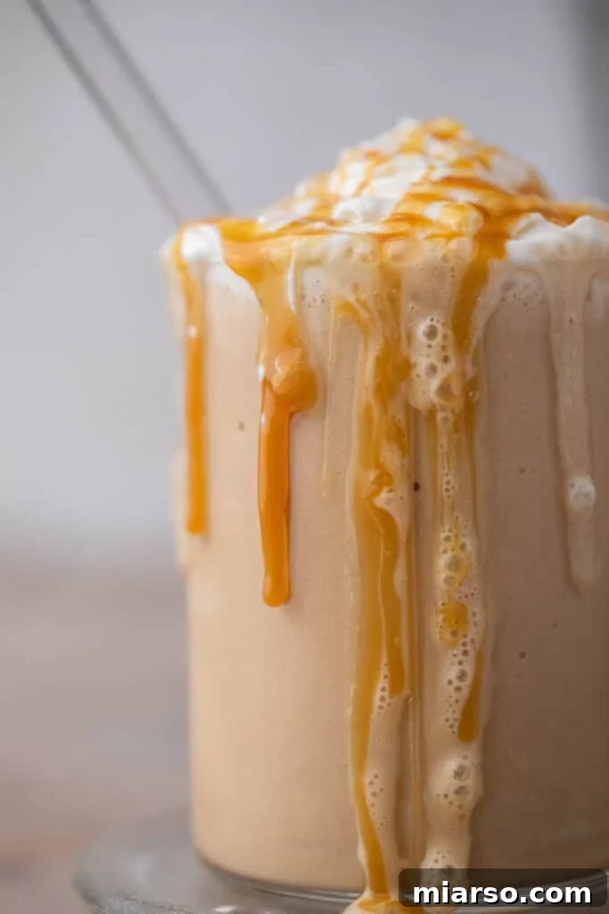 Close-up of caramel sauce dripping down a homemade caramel frappe