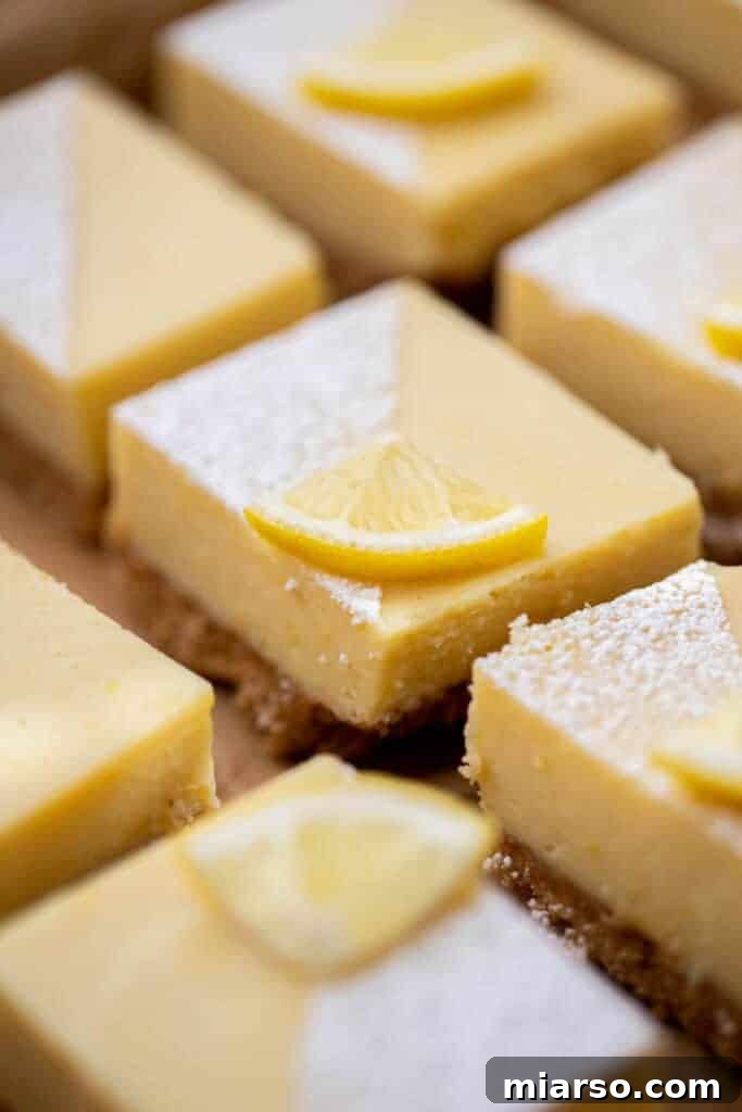 Lemon bar slices arranged neatly on a baking pan