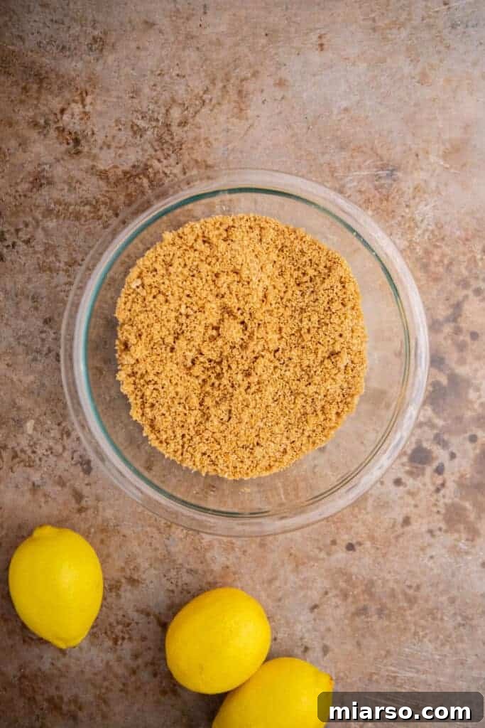 Graham cracker crumbs mixed with butter in a bowl