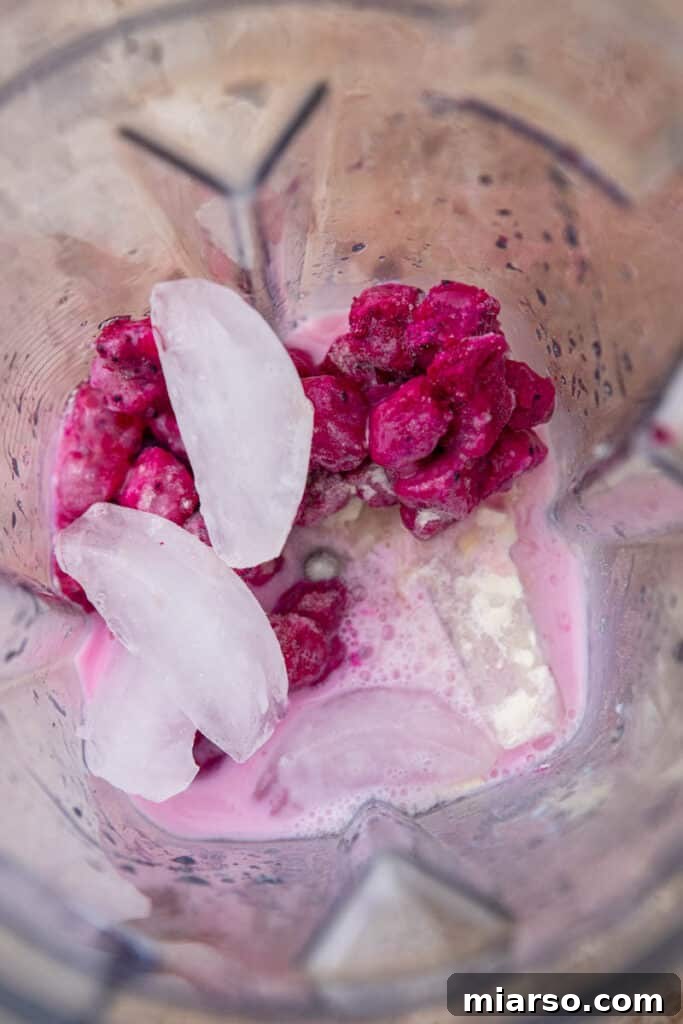 Dragon fruit, half and half, ice, and syrups in a blender.