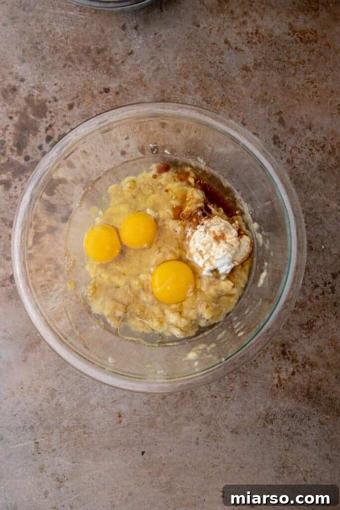 Wet ingredients for banana bread in a mixing bowl
