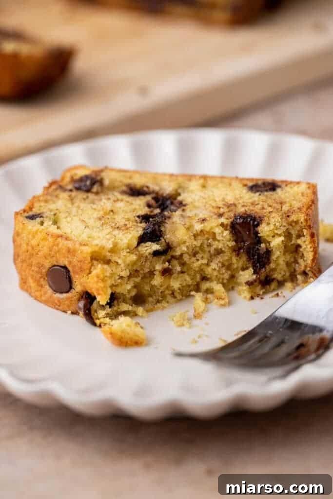 A perfectly sliced piece of banana bread with chocolate chips on a small plate