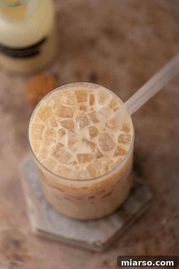 Close-up of an iced white chocolate mocha latte in a glass with a straw