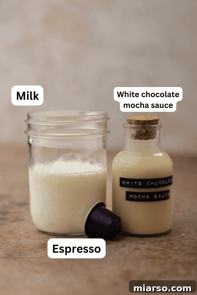 Ingredients for white chocolate mocha laid out on a kitchen counter, including milk, white chocolate sauce, and coffee beans.