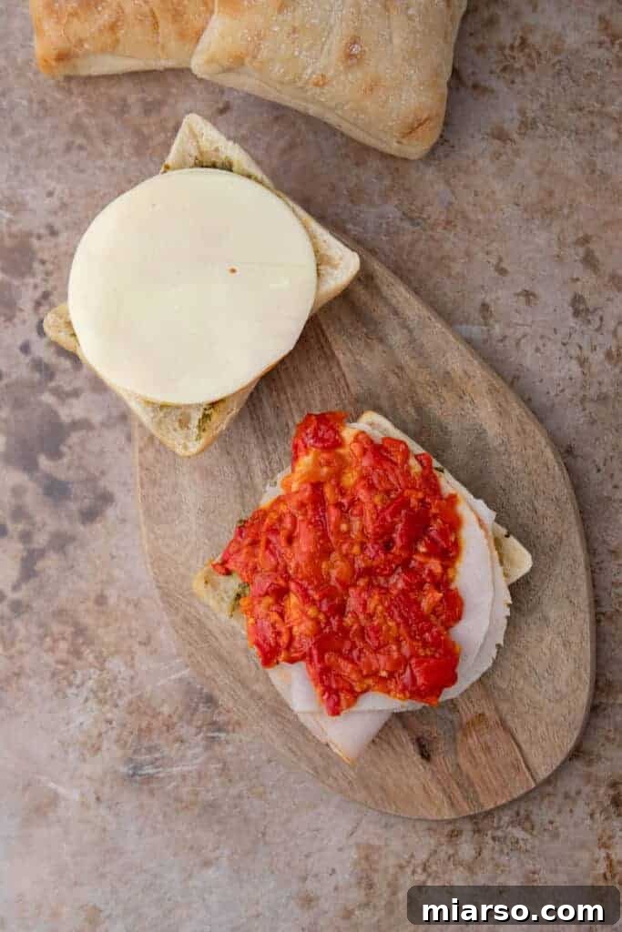 Building turkey pesto panini, showing layers of ingredients