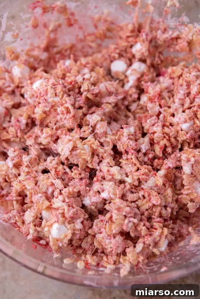 Strawberry rice krispies cereal mixture fully coated in marshmallow.