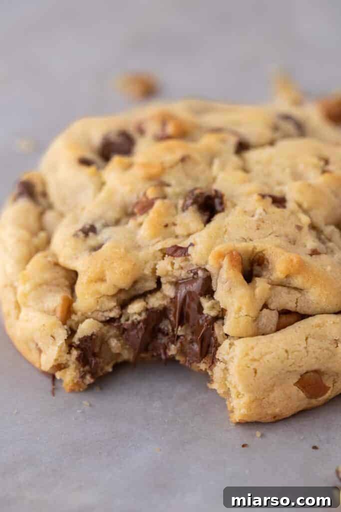 Close up of levain chocolate chip walnut cookie with a bite taken out of it
