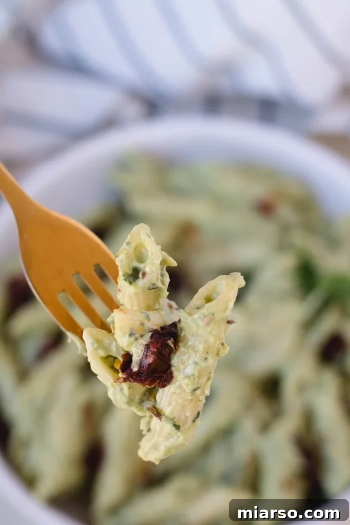 Easy vegan avocado sauce with pasta, fresh basil, and tomatoes