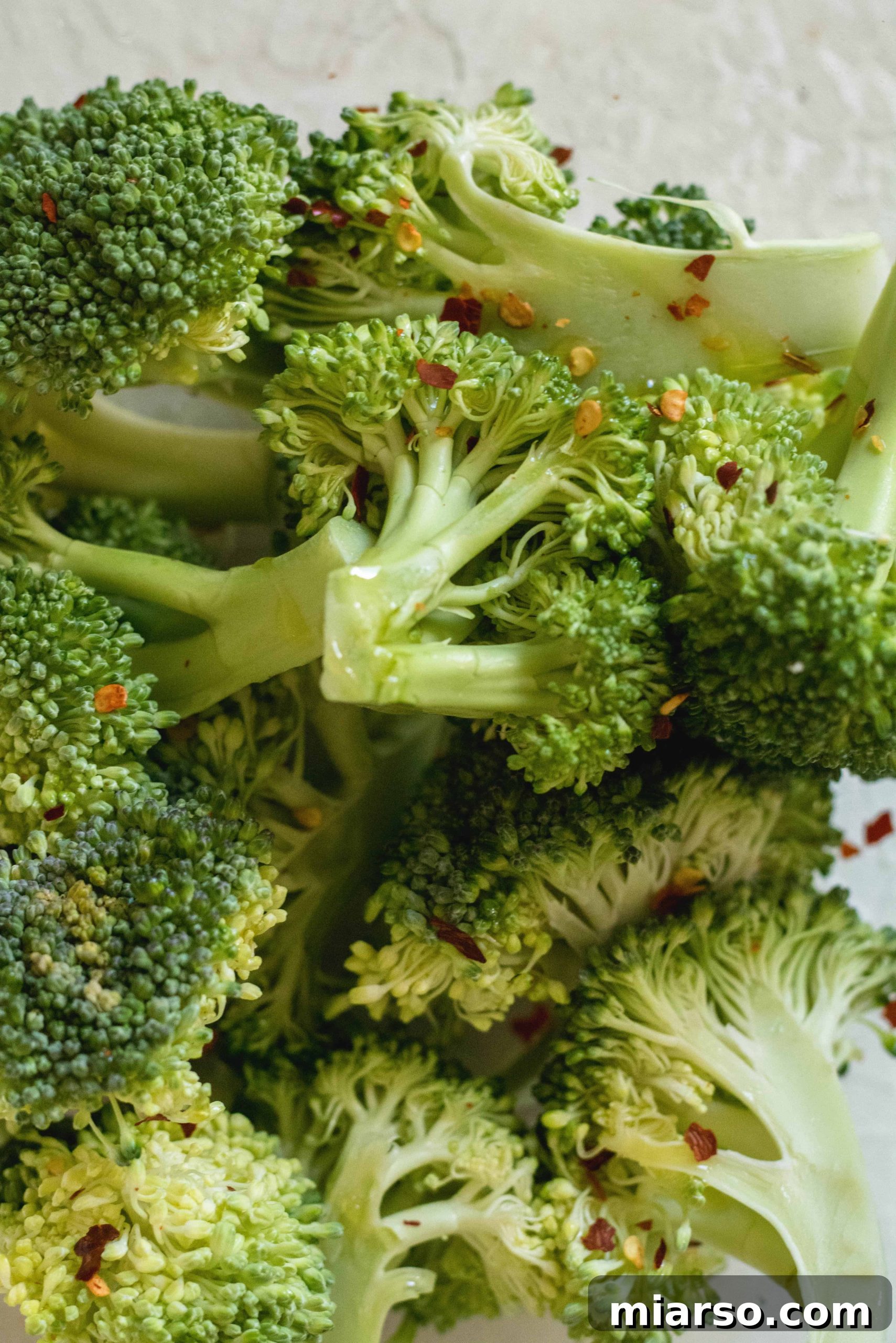Broccoli florets tossed with olive oil and spices, ready for air frying