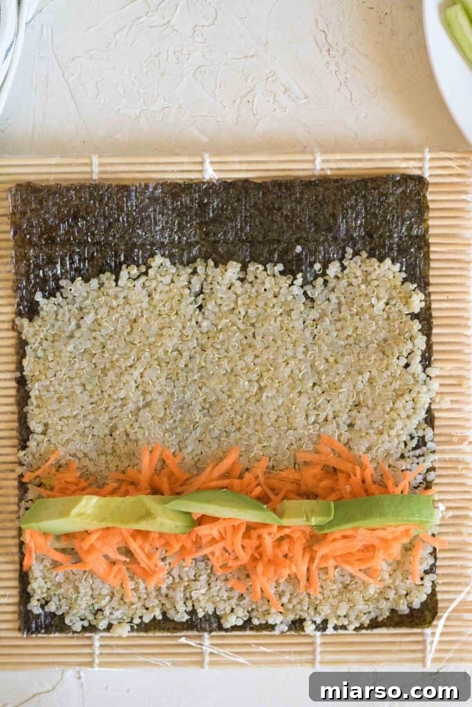 Adding avocado strips to the quinoa sushi roll.