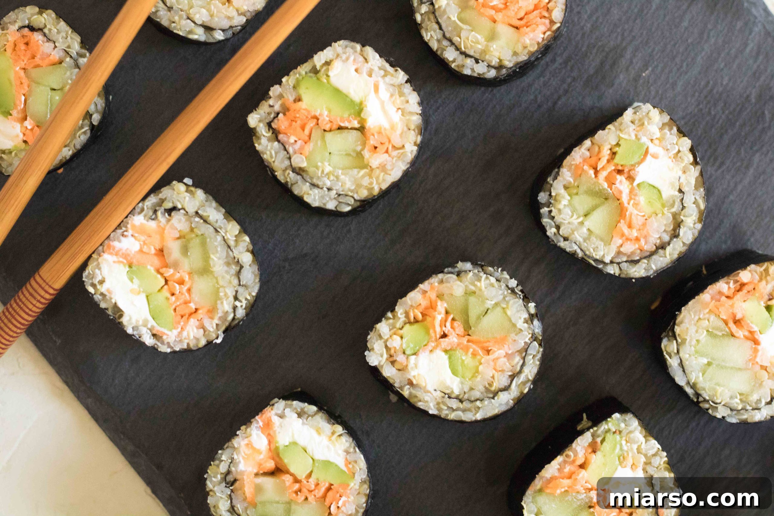 Plated vegetable quinoa sushi rolls with soy sauce and wasabi.