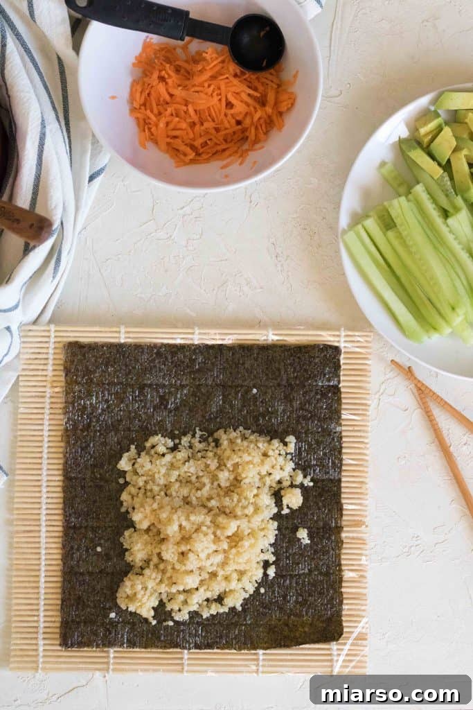 Plastic-wrapped bamboo sushi mat on a work surface.