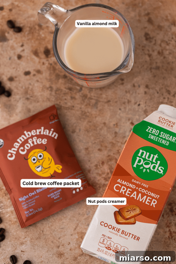 Ingredients for Emma Chamberlain's cold brew coffee laid out on a kitchen counter, including coffee bags, almond milk, and creamer.