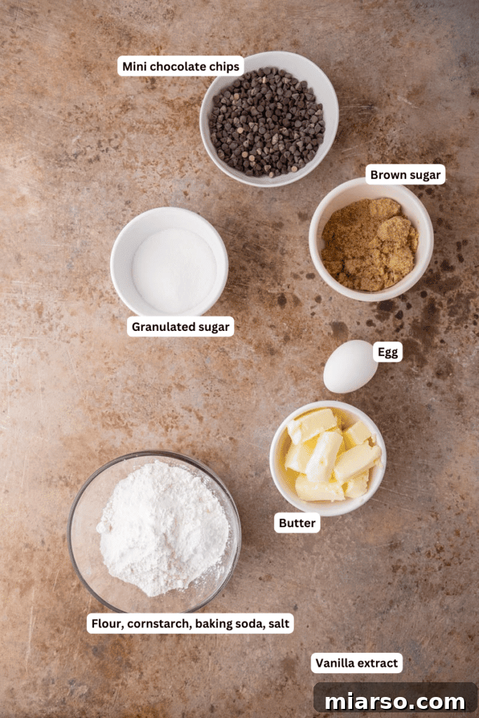 Neatly arranged bowls of ingredients for chocolate chip sugar cookies, including flour, sugar, butter, and mini chocolate chips.