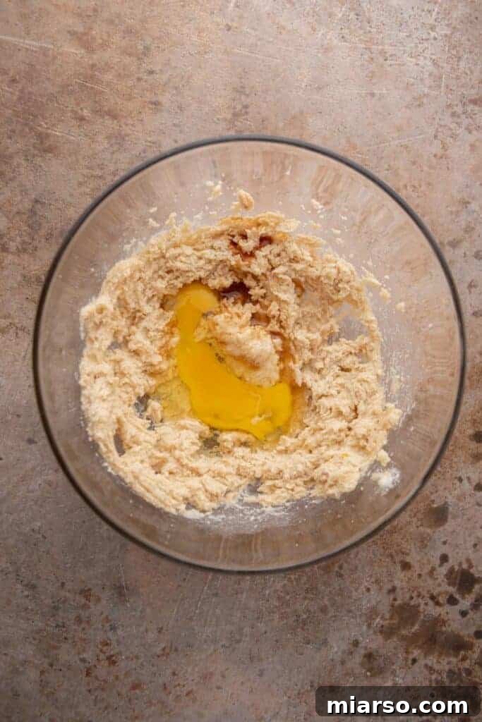 Creamed butter and sugar with egg added for cookie dough, showcasing the initial mixing stage.