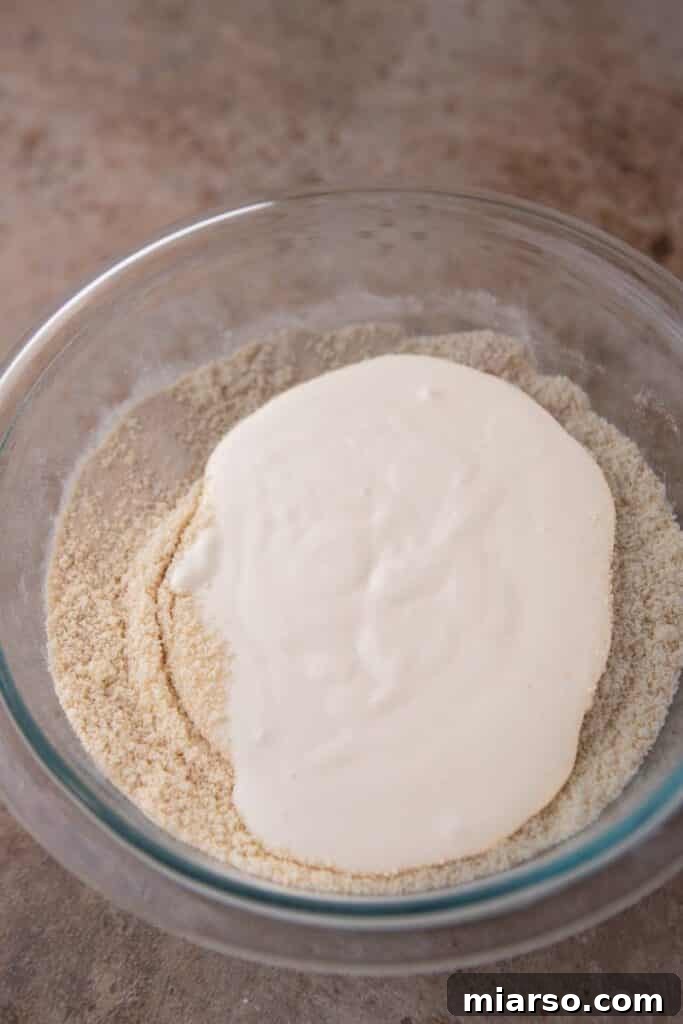 Dry ingredients and wet mixture combined in a bowl for cookie dough.