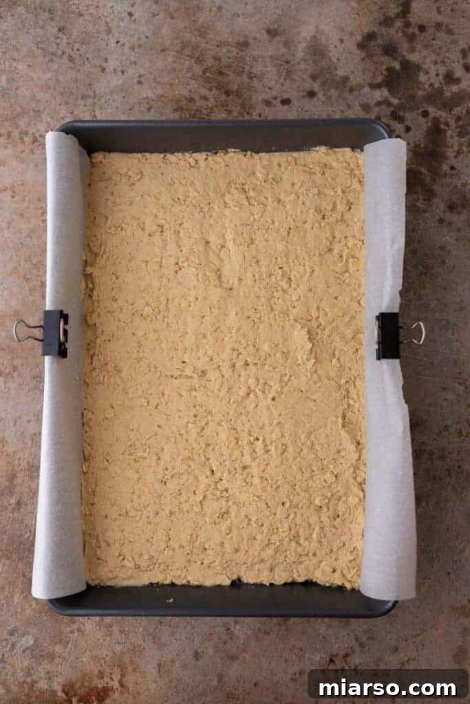 Decadent Starbucks Oat Fudge Bars 7 Oatmeal cookie dough pressed into a baking pan.