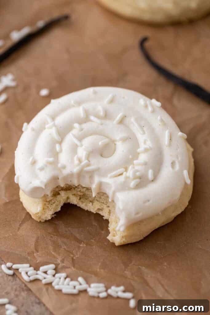A delicious Crumbl Nilla Bean Cupcake Cookie with a bite taken out, showcasing the thick cookie base and creamy frosting.