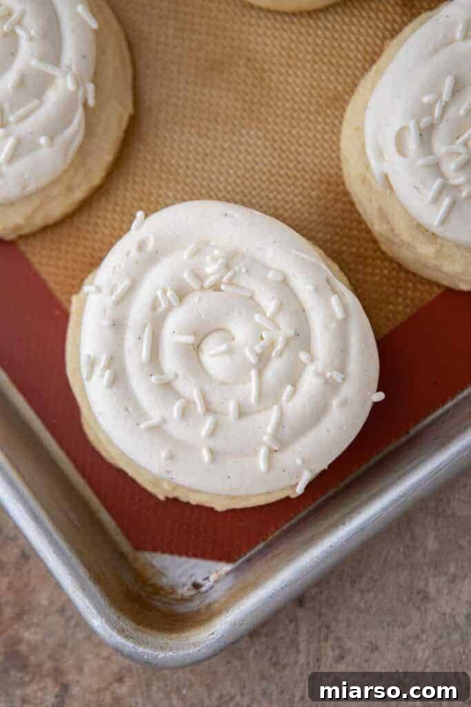 A Crumbl Nilla Bean Cupcake Cookie cooling on a baking sheet, showing its perfect shape.