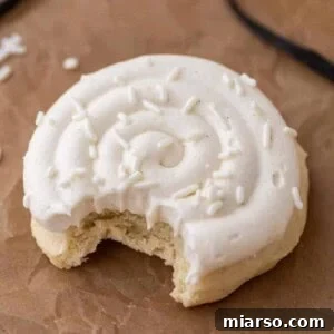 Crumbl Nilla Bean Cupcake Cookie with a bite taken out of it, showcasing the thick cookie base and creamy frosting
