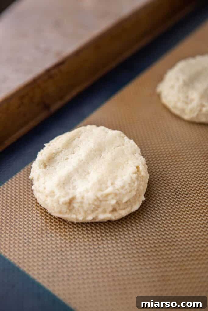 More cookie dough on a baking sheet, showing the flattened shape before baking.
