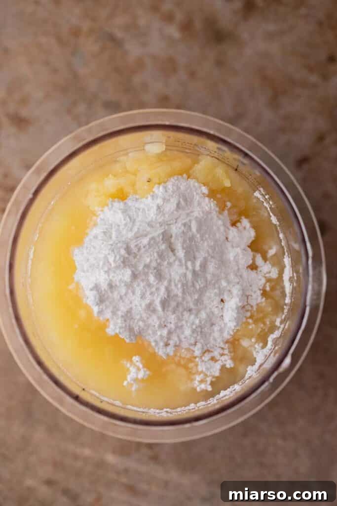 Crushed pineapple and powdered sugar stirred in a Ninja Creami cup before freezing.