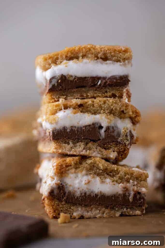 A stack of golden brown s'mores cookie bars on a cooling rack.