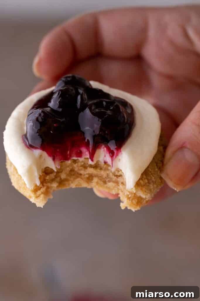 Crumbl blueberry cheesecake cookies with cream cheese frosting and blueberry topping