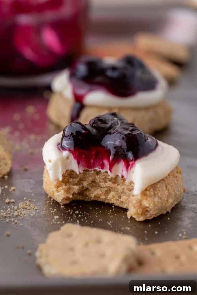 A Crumbl blueberry cheesecake cookie with a bite taken out of it, showing the layers