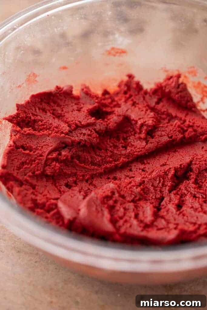 Finished Crumbl red velvet cupcake cookie dough in a bowl, a rich, deep red color.