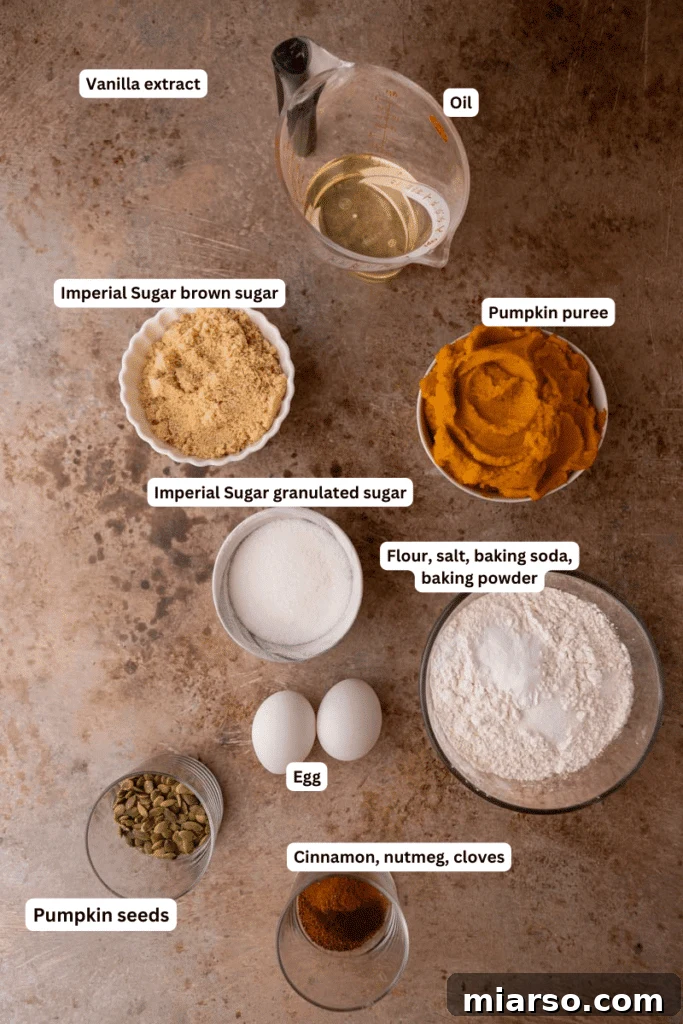 All the dry and wet ingredients for making pumpkin bread laid out neatly on a kitchen counter.