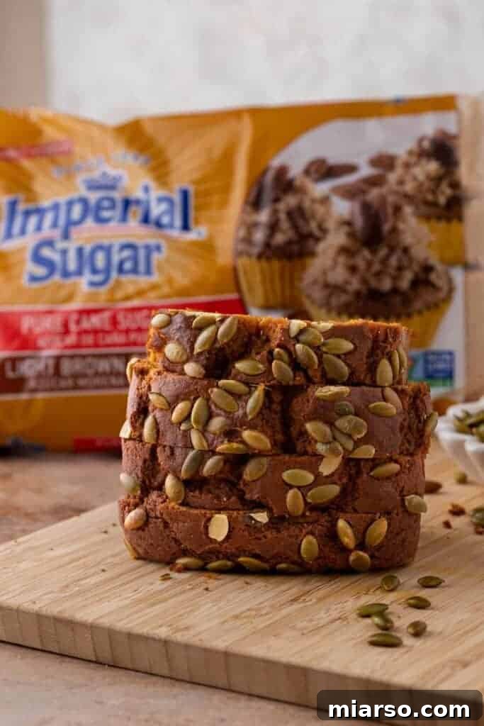 A freshly baked pumpkin bread loaf next to a bag of Imperial Sugar, highlighting the quality ingredients used.