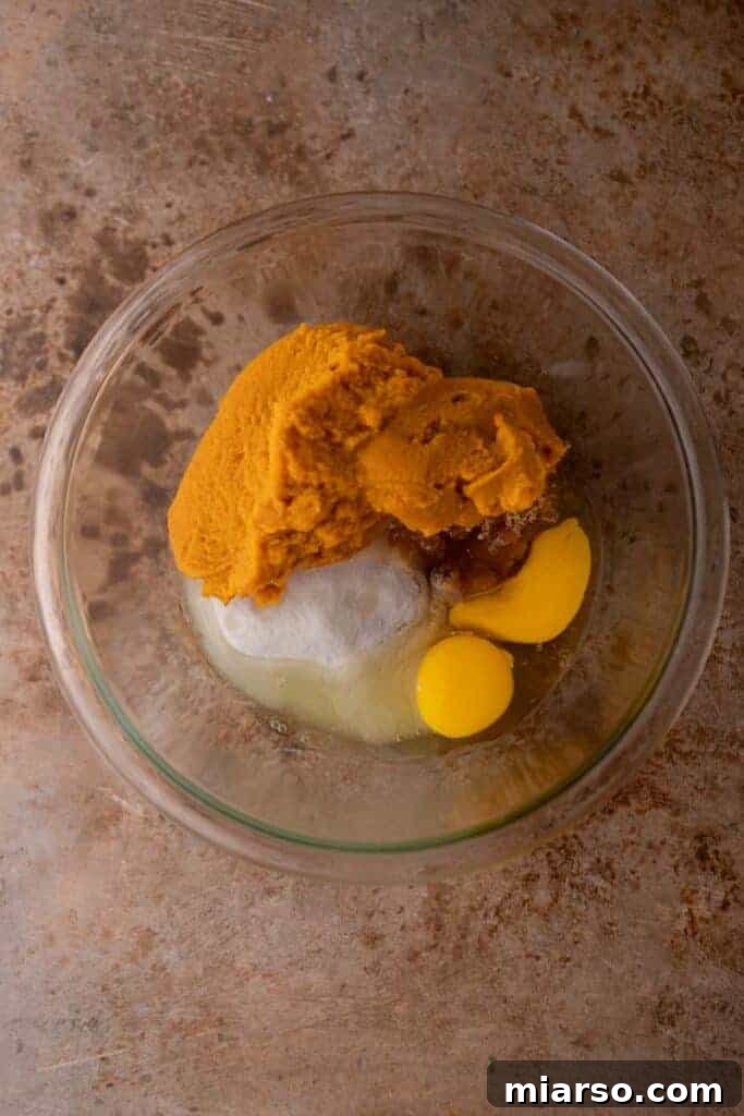 Wet ingredients for pumpkin bread being whisked in a bowl.