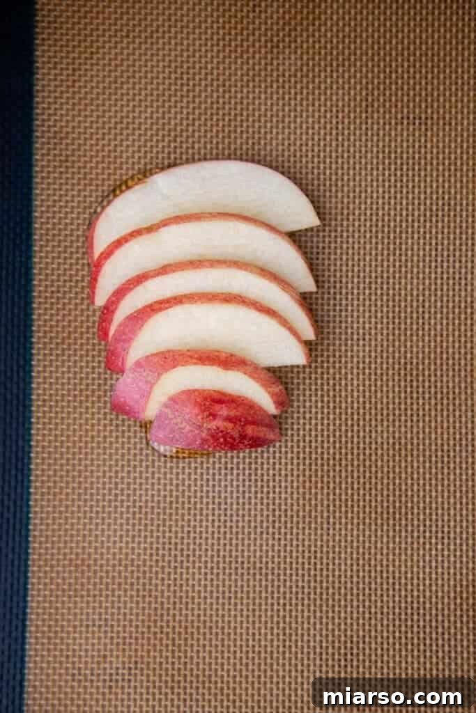 Sliced apples arranged on a baking sheet