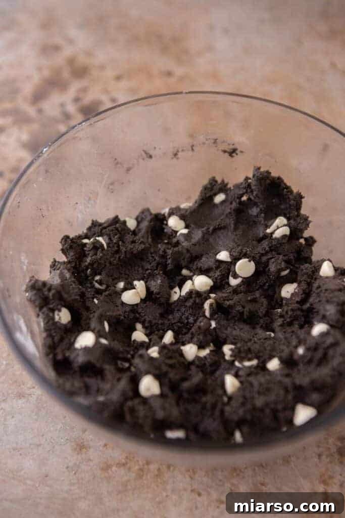 Crumbl's Chocolate Cookies & Cream Bliss 7 Fully mixed cookie dough with white chocolate chips and chopped Oreos folded in, ready for scooping.
