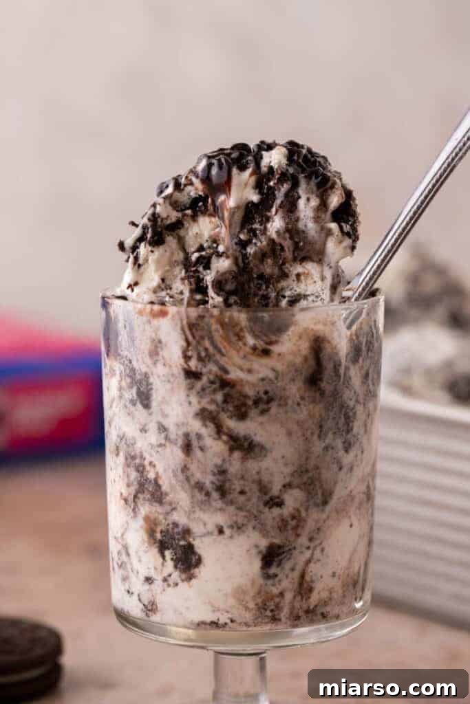 Simply Delicious No Churn Oreo Ice Cream 11 Close-up of creamy Oreo ice cream drizzled with rich chocolate sauce, highlighting its indulgent texture and visible cookie pieces.