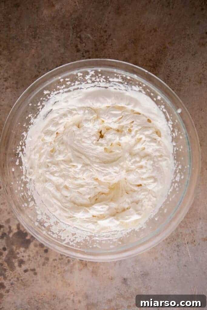 Simply Delicious No Churn Oreo Ice Cream 4 Freshly whipped heavy cream in a large mixing bowl, ready for the next step of making no-churn ice cream.