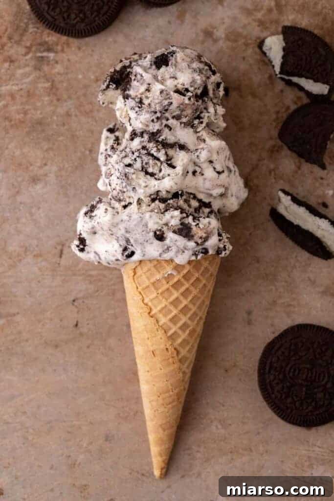 Simply Delicious No Churn Oreo Ice Cream 10 A perfect scoop of no-churn cookies and cream ice cream sitting in a waffle cone, ready to be enjoyed.