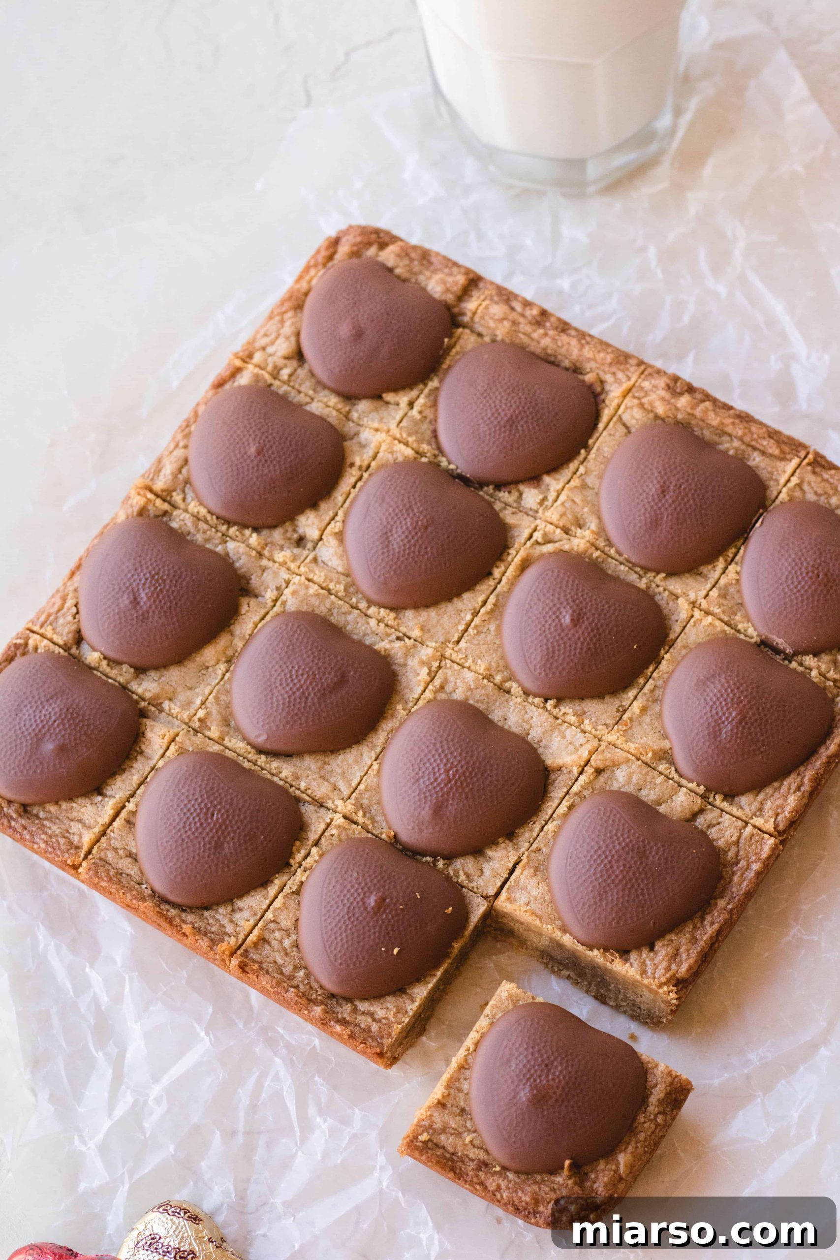 Moist, rich peanut butter blondies topped with Reese's hearts, perfect for a treat.