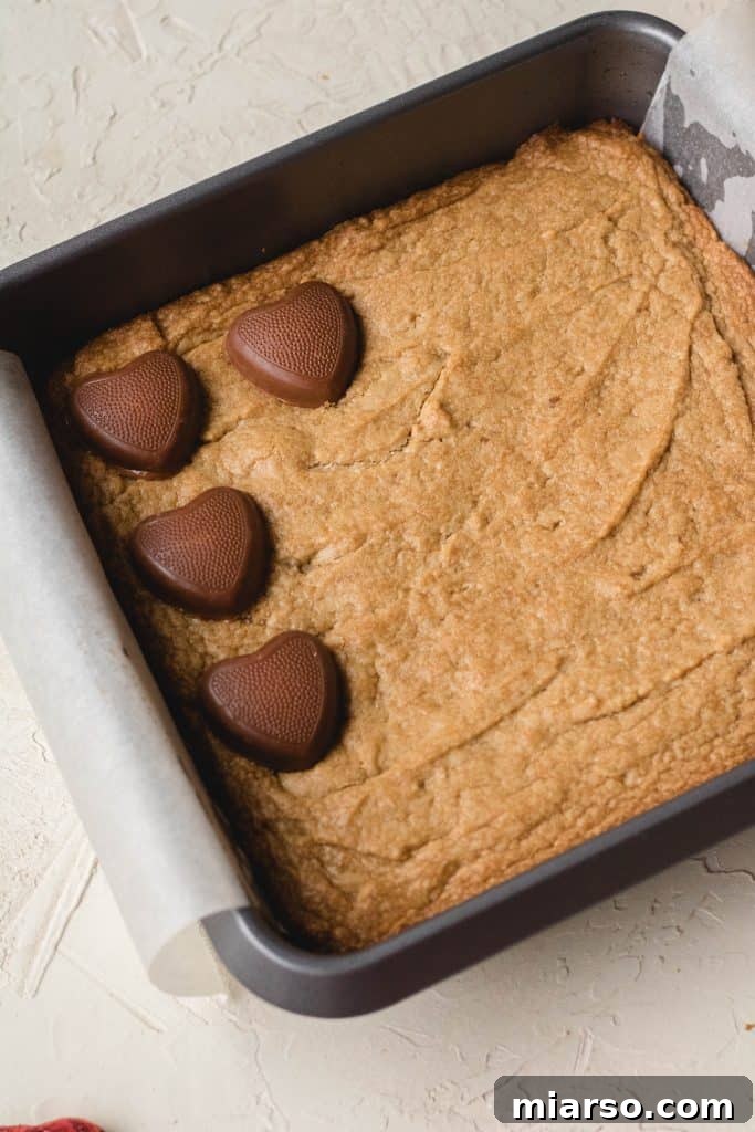 Evenly spreading peanut butter blondie batter in the baking pan.