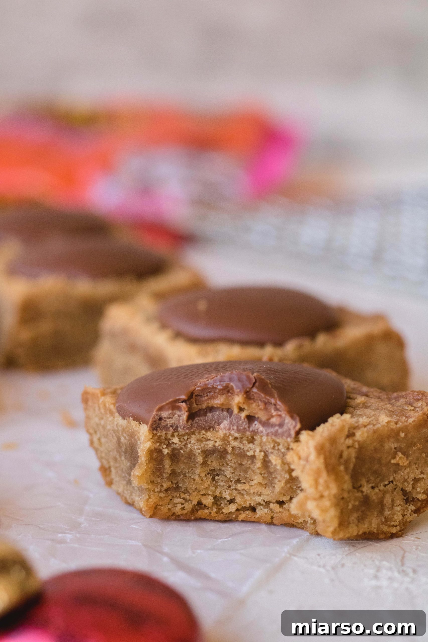 Freshly baked peanut butter blondies with Reese's candies pressed on top.