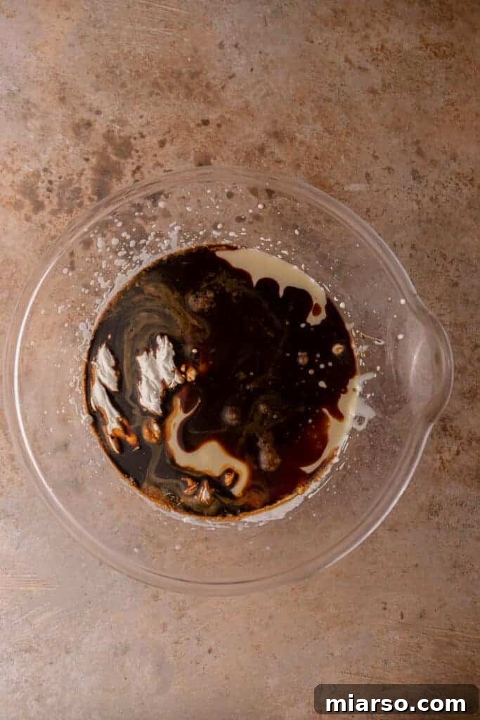 Instant coffee granules dissolving in hot water, preparing the coffee base for the ice cream.