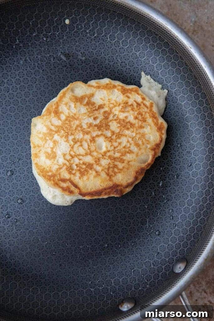 Fluffy Pancakes: No Milk, No Fuss 6 Golden pancake cooking in a skillet with crisp edges