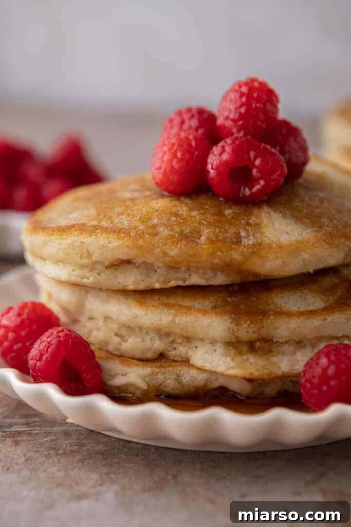 Fluffy Pancakes: No Milk, No Fuss 8 Stack of dairy-free pancakes topped with fresh raspberries