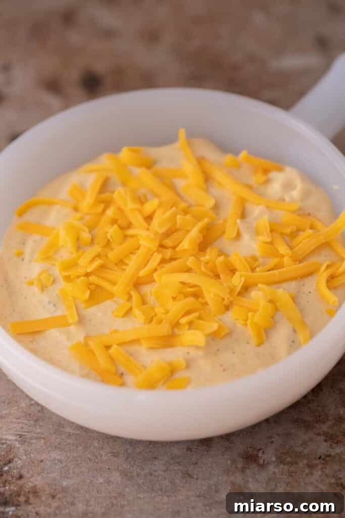 Finished cottage cheese queso in a serving bowl with toppings