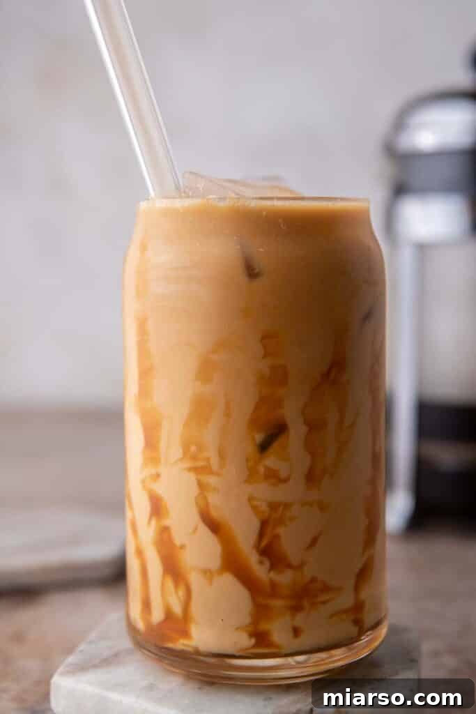Quick 5-Minute Iced Caramel Coffee Perfection 4 Close-up of a glass of iced caramel coffee, showing the layers of coffee, milk, and caramel drizzle.
