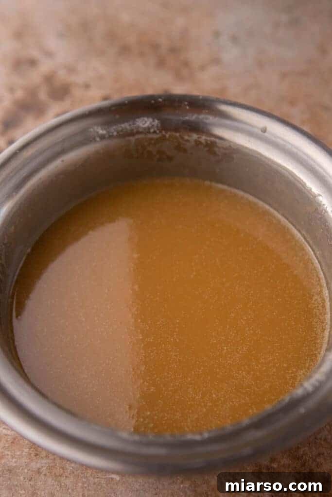 Crafting the Perfect Homemade Caramel Apple Dip 7 Finished homemade caramel sauce pouring smoothly into a jar, demonstrating the perfect consistency.
