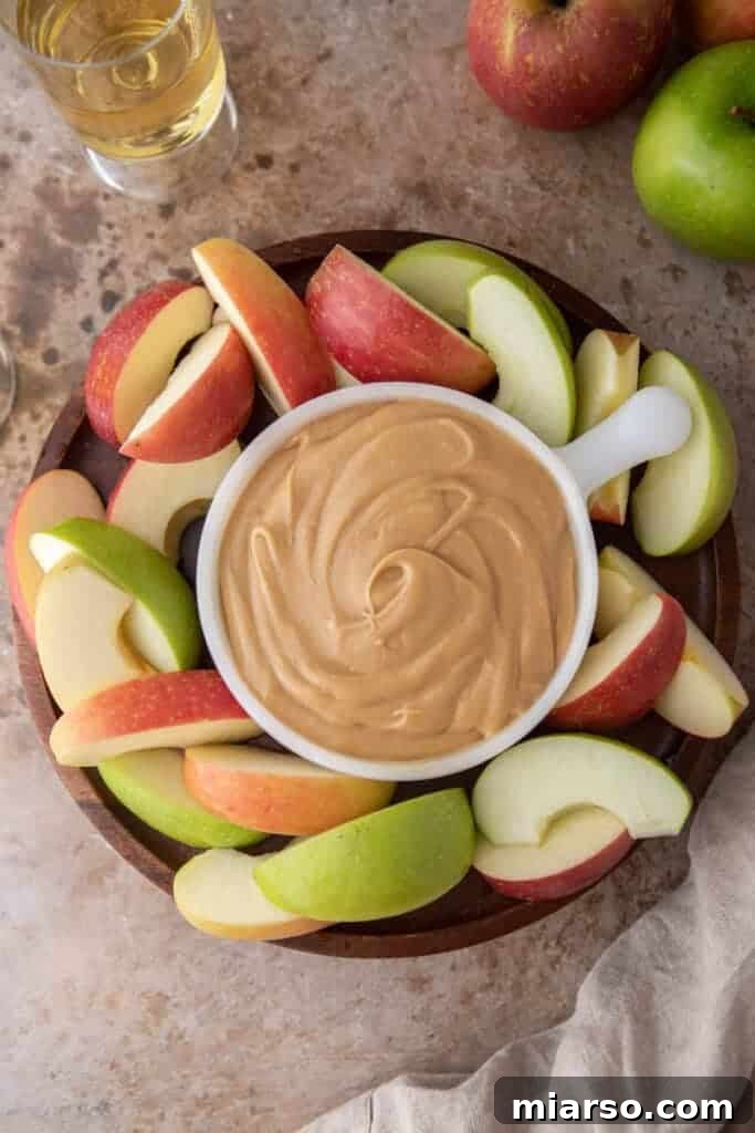 Crafting the Perfect Homemade Caramel Apple Dip 9 A beautiful serving board featuring a bowl of caramel sauce dip surrounded by perfectly sliced apples, ready to be enjoyed.