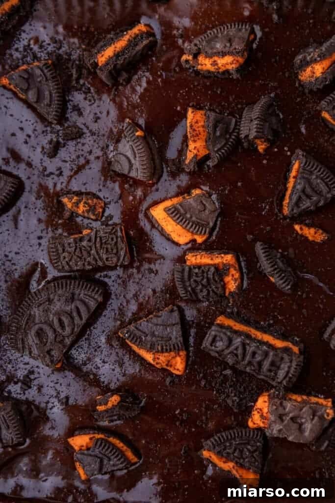 A close-up of the Halloween Oreo brownie batter in the pan before baking, showing the Oreos embedded within and on top.