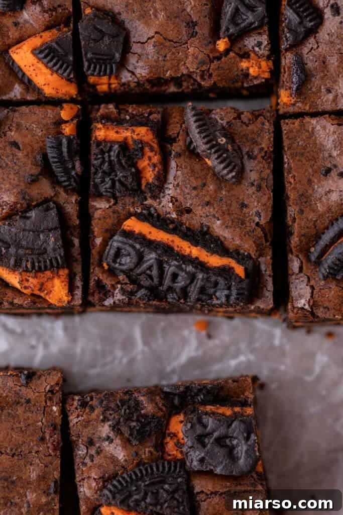 Close-up of freshly baked Halloween Oreo brownies with a crinkly top and visible Oreo pieces.